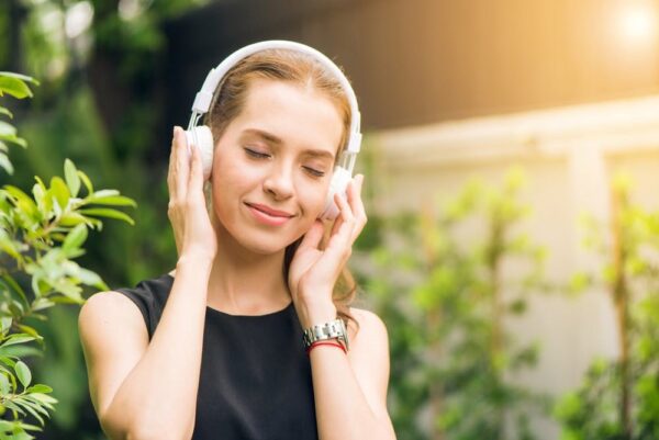 Woman enjoying music outdoors for self-care