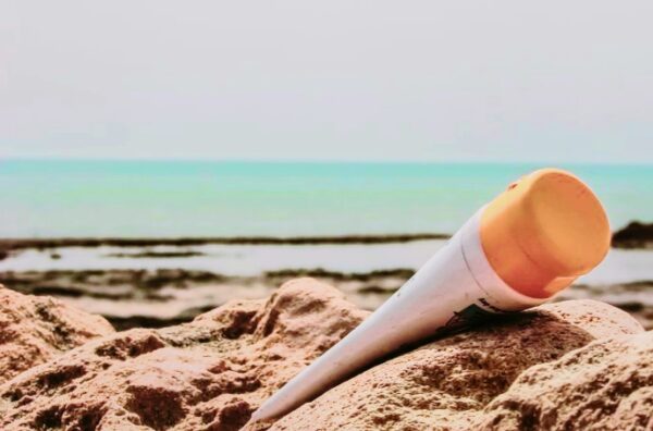 sunscreen tube laying on beach